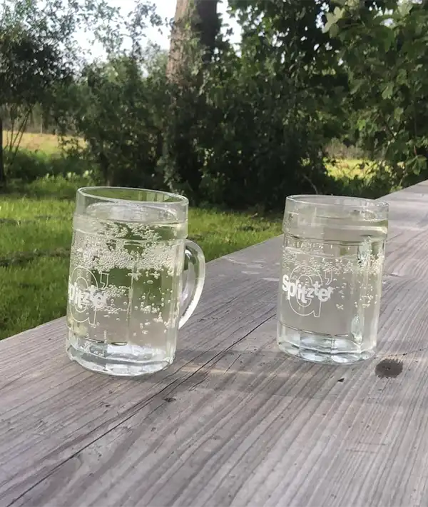 Zwei Gläser G'spritzte auf einem Holztisch in der Radlerrast