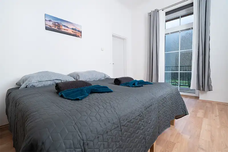 revLIVING Apartments - gemütliches Schlafzimmer mit Bett und Fenster